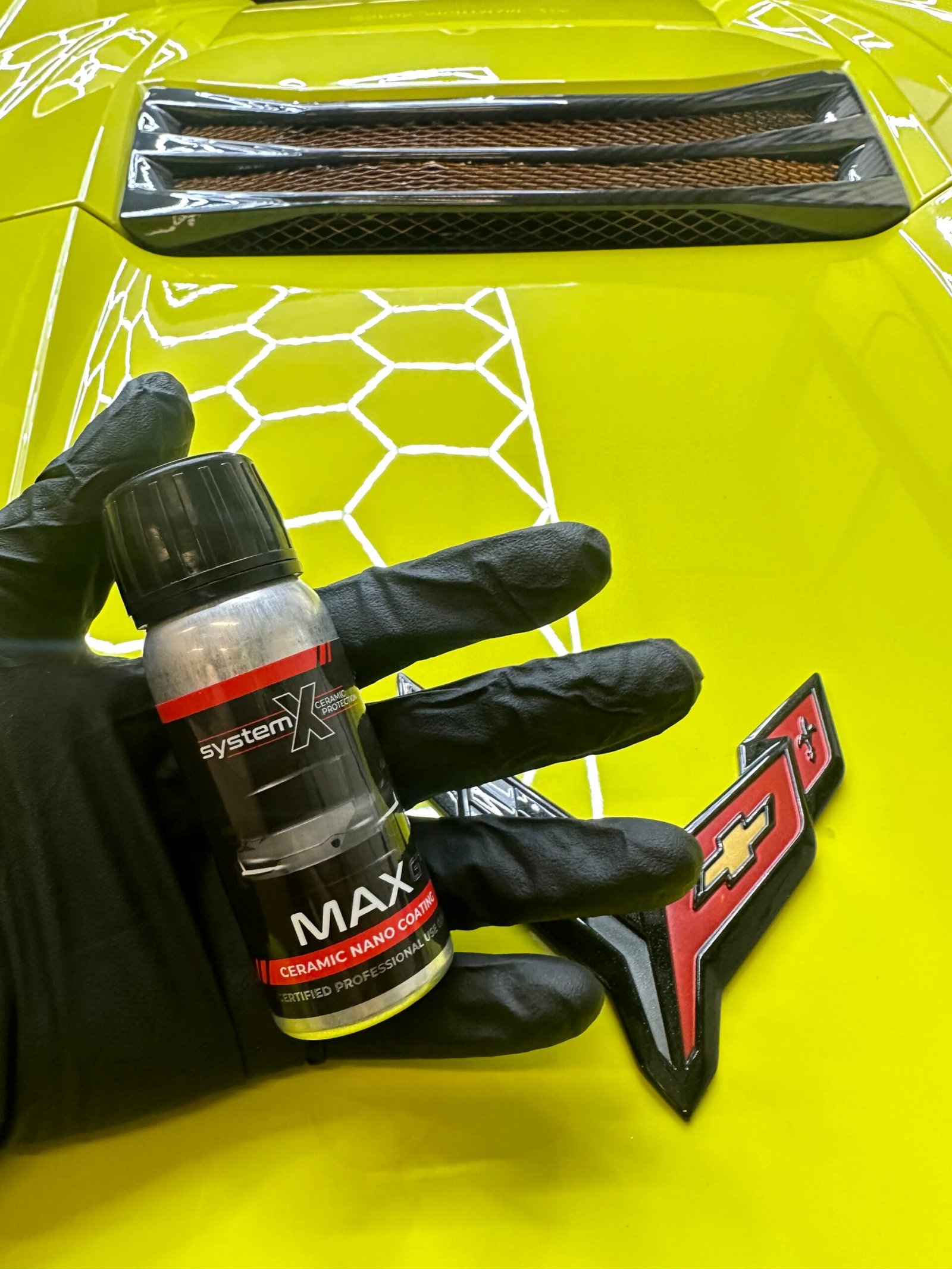 System X Ceramic Coating bottle in front of a corvette